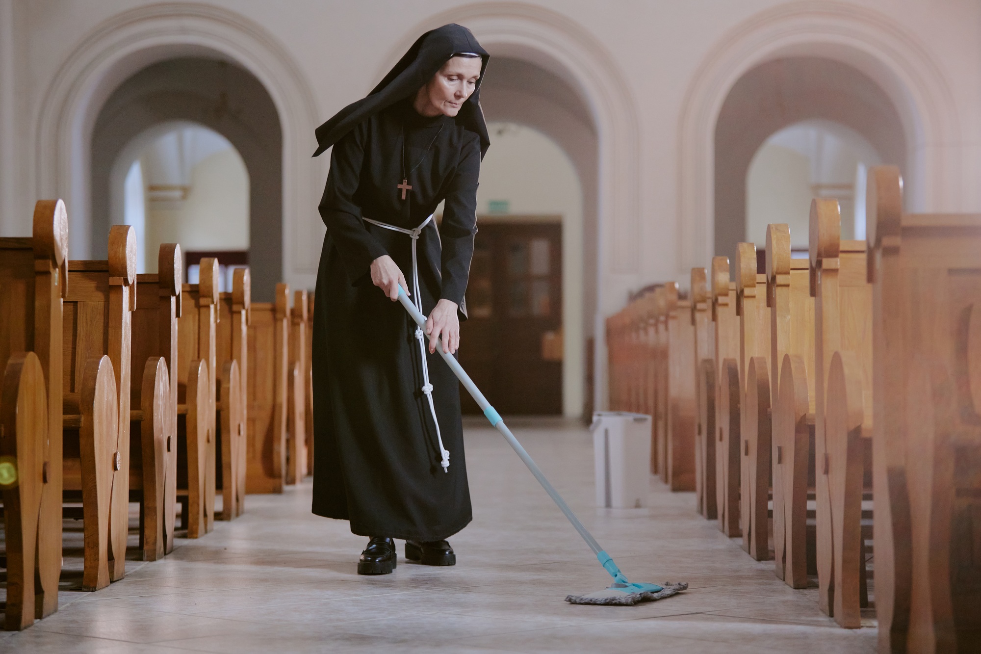 Senior Nun Wiping Floor In Church