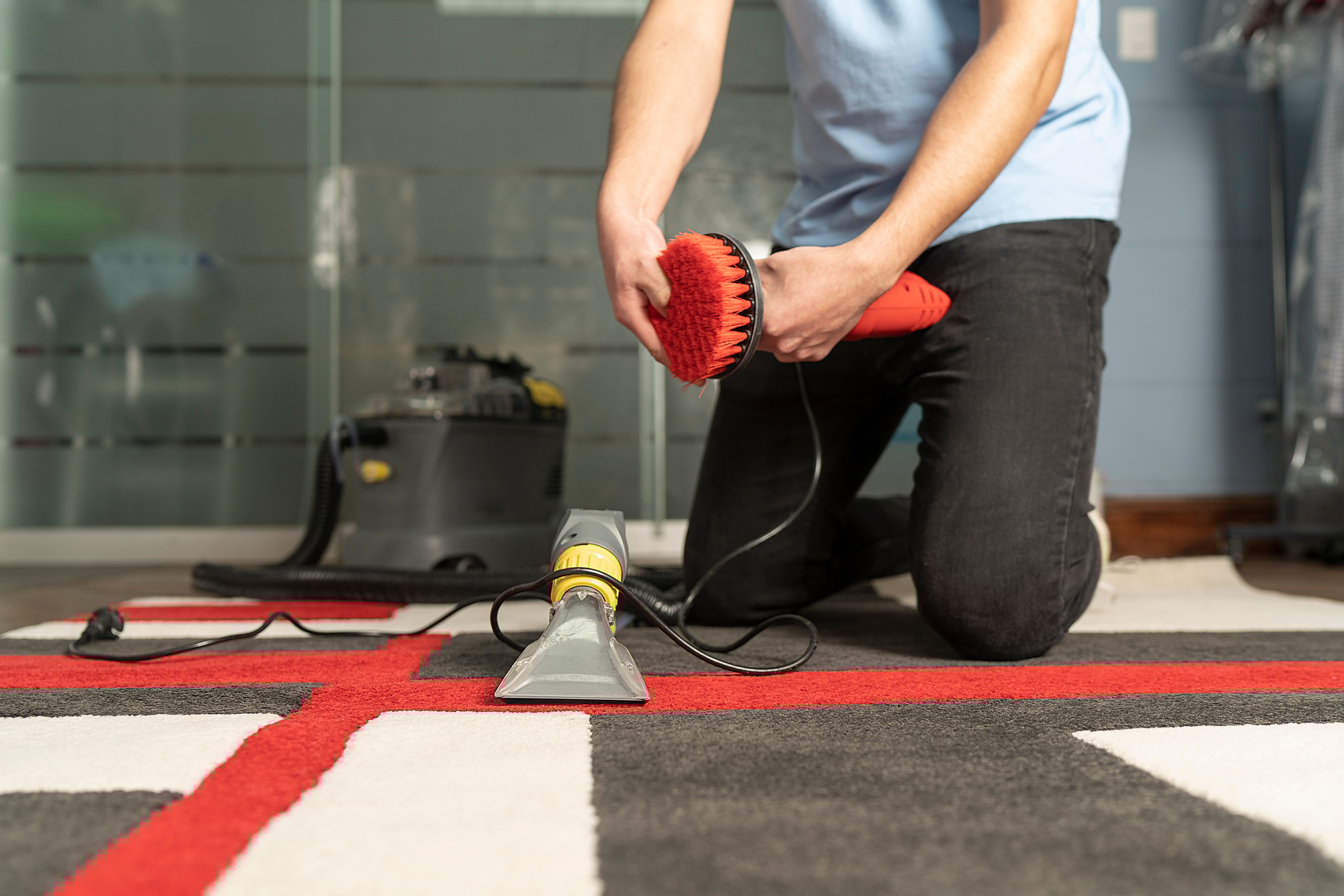 Unrecognizable laundry personnel cleaning carpet with special equipment